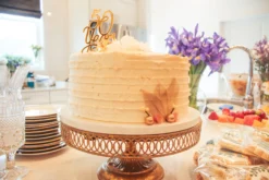 50th anniversary cake - golden shimmer icing sitting on an antique gold lattice cake stand