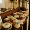 Close up on cupcakes on the shelf of a dark wood vintage mantle with a mirror