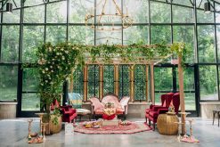 Ornate ceremony setup with a wall of windows in the background.