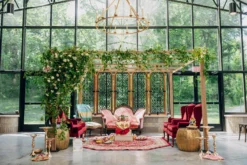 Ornate ceremony setup with a wall of windows in the background.
