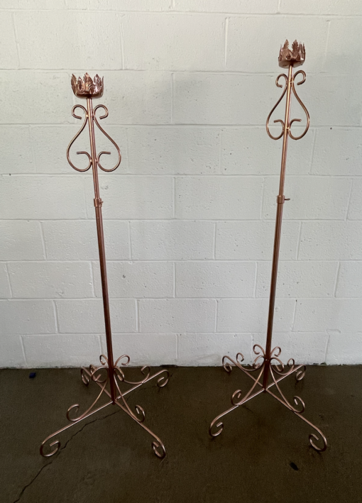 Two matching copper floor standing candle sticks