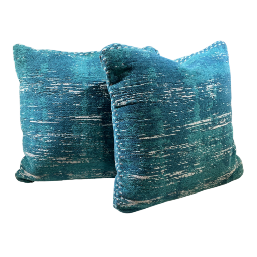 Teal square pillow with flecks of green, cream, blue.