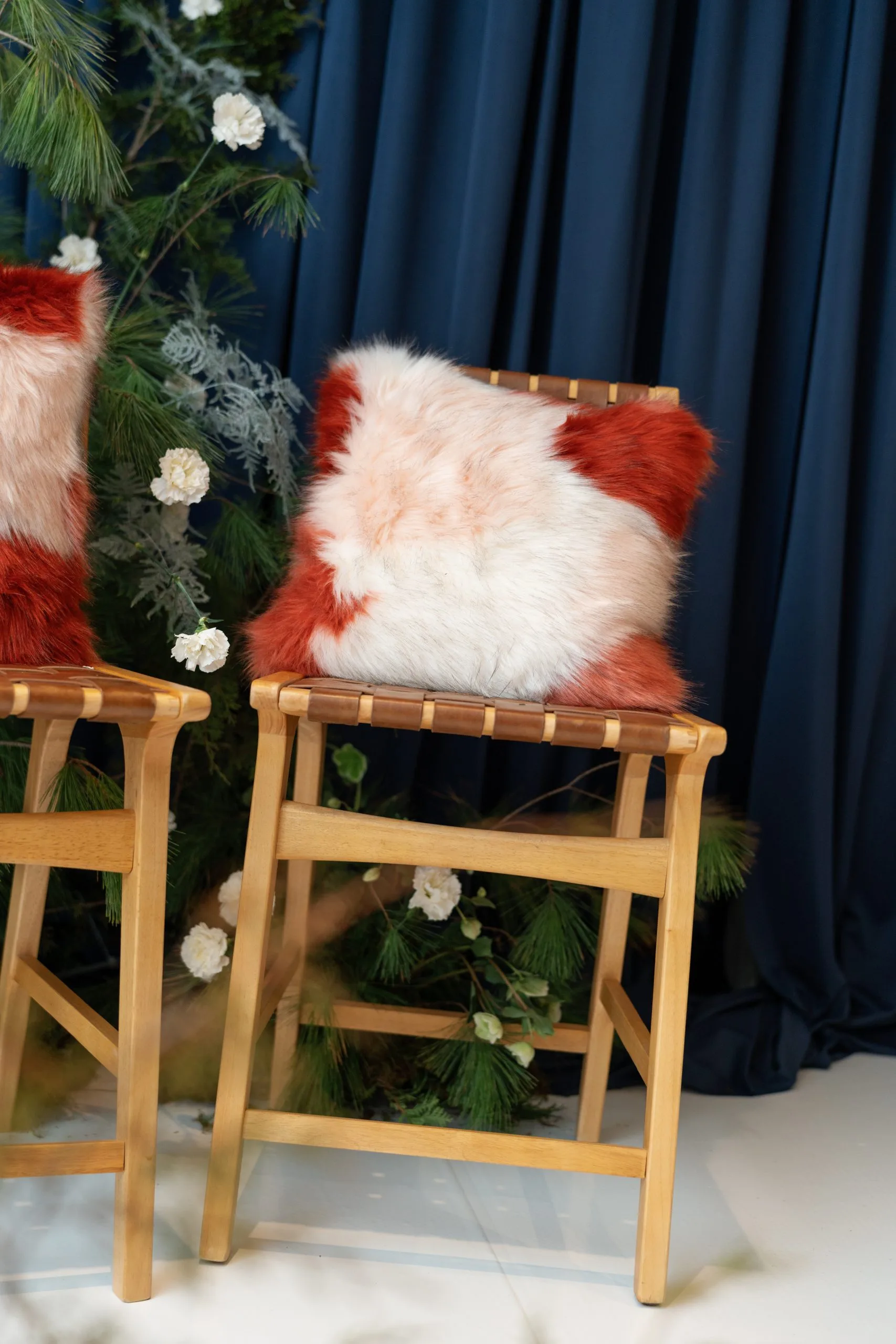 Pillow at launch event WEBP Stafford Pillow for rent at Violet Vintage Indianapolis: A square, high-texture faux fur decorative pillow featuring a soft color-blocked pattern of rust orange and creamy white long-pile fur for event lounge styling.