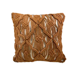 Square off white pillow with burnt orange / rust colored macrame in designs over the pillow.