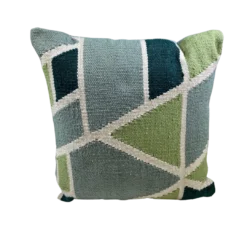 Pillow with geometric shapes in green, light blue, dark blue with white lines between shapes