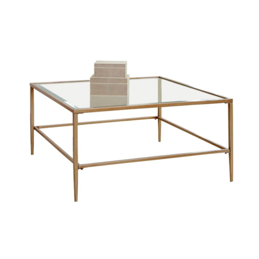 Large square coffee table with muted gold edges, legs and a glass top.