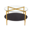 Modern round coffee table with glass top, gold legs that form an X on the top, and a black bottom shelf