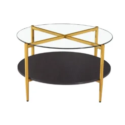 Modern round coffee table with glass top, gold legs that form an X on the top, and a black bottom shelf
