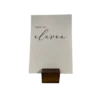 Small dark wood place card holder holding a piece of thick paper with a table number printed on it