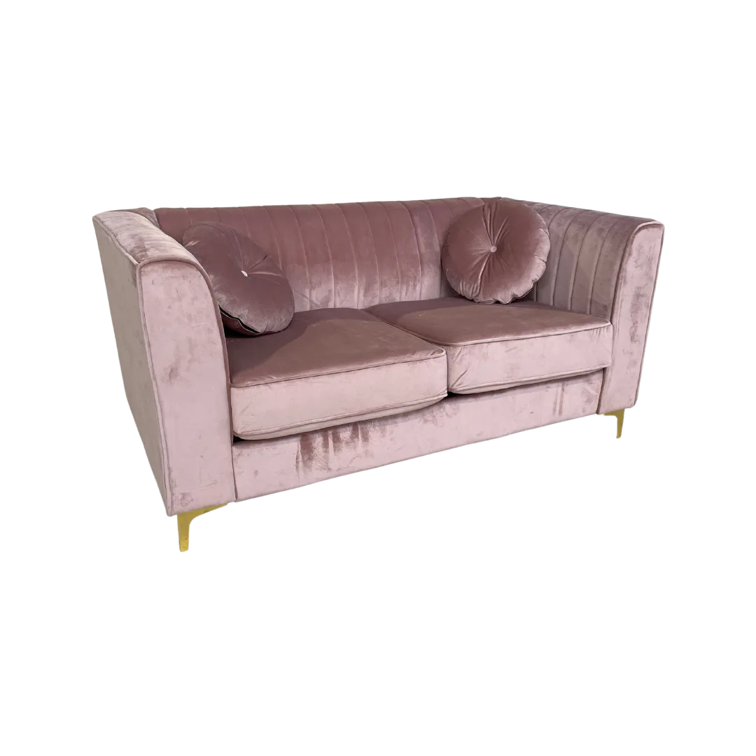 Avianna Loveseat Settee Angle WEBP Soft pink velvet sofa with tufted back, two large cushions, square arms and gold legs. Includes two round matching pillows. Side view