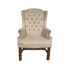 Tan high back wing chair with button tufting and nail head trim on arms. Dark wood legs.