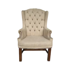 Tan high back wing chair with button tufting and nail head trim on arms. Dark wood legs.