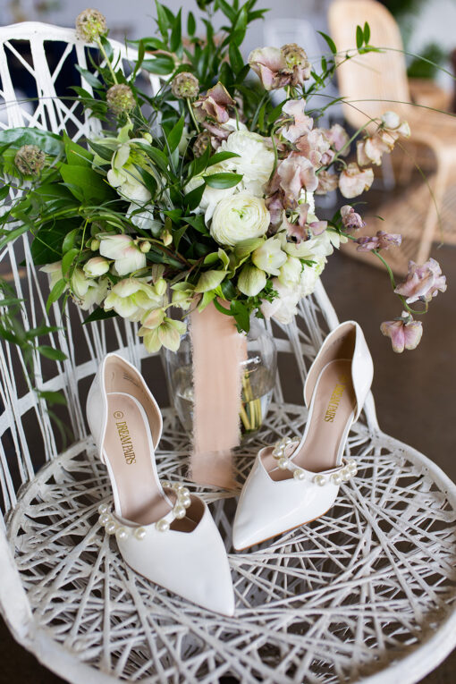 White MCM fiberglass chair with florals and white heeled shoes