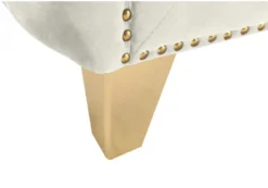 Close up on gold foot with nailhead trim.