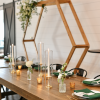 Wedding head table with backdrop behind. Tablesetting with white, deep green and gold votives.