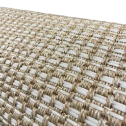 Close up on texture of Edwin Rug. White woven lines in a repeating pattern on tan backing.