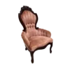 Victorian arm chair with pink velet, channel tufted back, dark wood ornate trim and rolled arms.