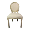 A french style chair with light wood framing and cream upholstered back and seat.