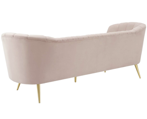 Back of a rounded velvet blush velvet sofa. Gold legs