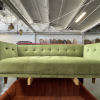 Pear green velvet sofa on a rack in an industrial warehouse