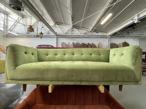 Pear green velvet sofa on a rack in an industrial warehouse