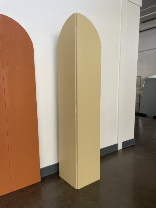 Wooden arch panels over 7 feet tall. Two panels shown - one is burnt orange and flat and the other is beige and folded.