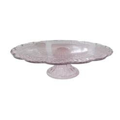 Light pink glass pedestal cake stand with scalloped edges.