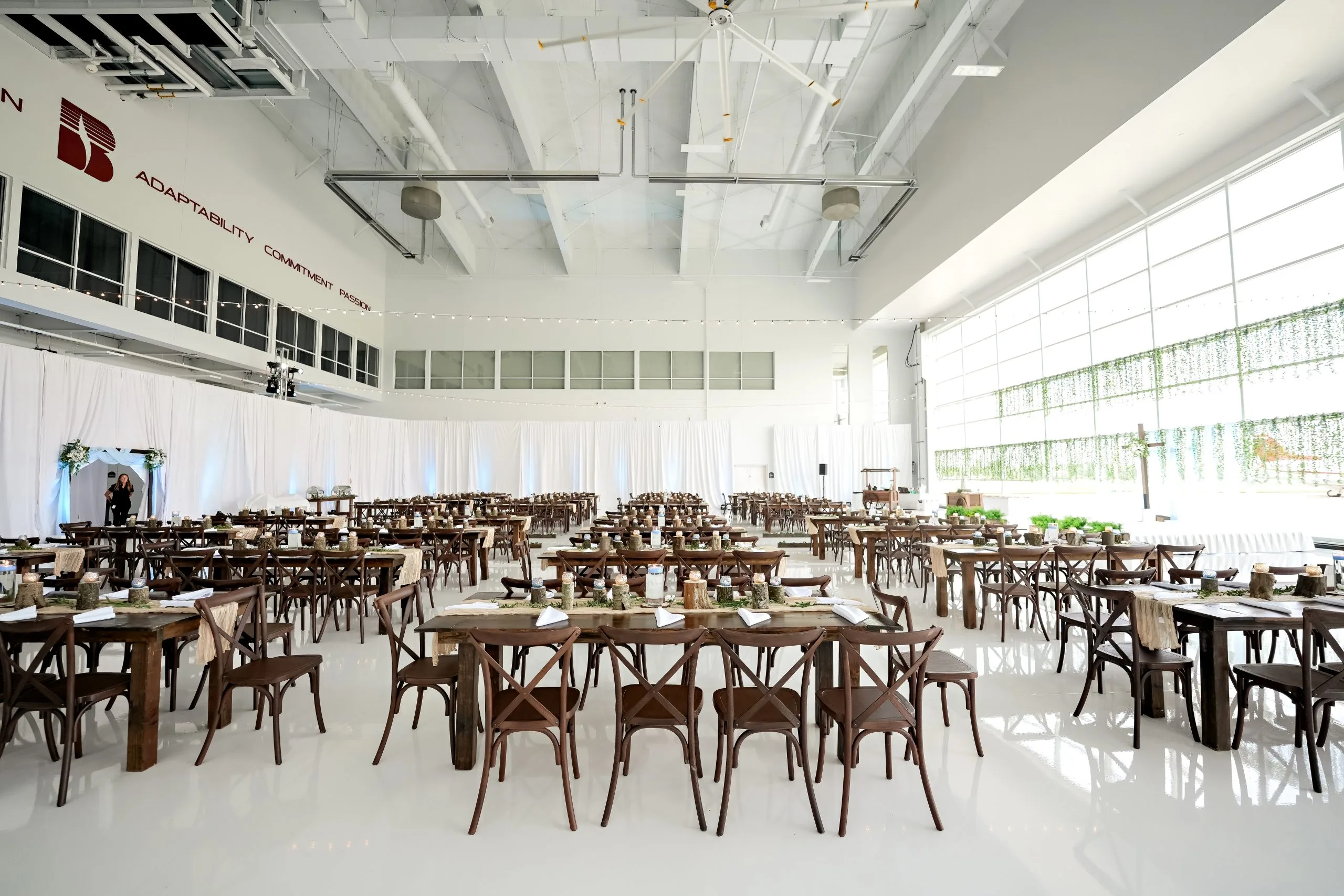 dark vineyard chairs at wedding WEBP dark vineyard crossback chairs and dark wooden farm tables in an airport hangar turned into wedding reception