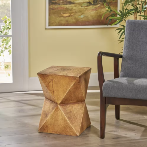 Accent table next to gray chair with wooden arms against a yellow wall.