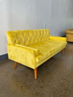 Side angle of yellow velvet sofa rental