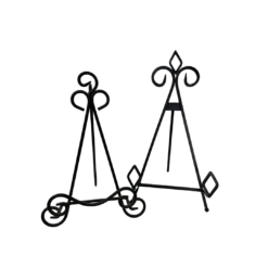 Two mismatched black metal table top easels. One has a pointy top and one has more curved design.