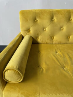 Close up of arm pillow and back of yellow sofa.