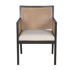 Dark wooden chair with strong angles. Cane on back and arms. Cream upholstered seat.