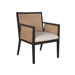 Dark wooden chair with strong angles. Cane on back and arms. Cream upholstered seat.