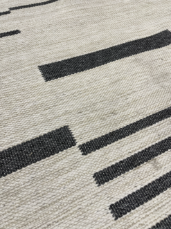 Close up on the dark gray bars woven into the rug.