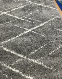 View of the gray rug with white lines making geometric overlapping diamonds.
