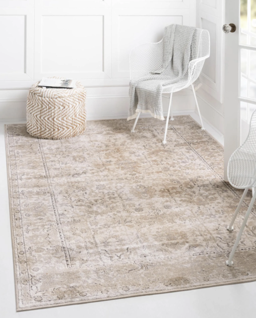 Rug placed on a white floor with white walls and white chairs with a neutral pouf