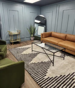 Leather sofa against blue gray walls with a geometric black and white rug.