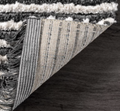 Corner of the rug turned up to show the jute backing.