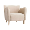 Velvet wing arm chair in beige. Scallop top, high arms, light wooden legs.