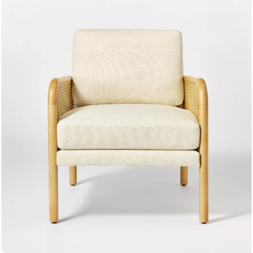 Front facing chair with cream boxy cushions at the back and seat. Light wooden arms and legs.