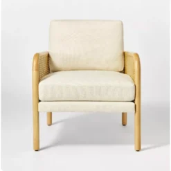 Front facing chair with cream boxy cushions at the back and seat. Light wooden arms and legs.