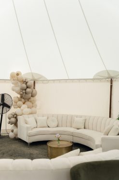 Cream curved sectional with a gold coffee table under a white test