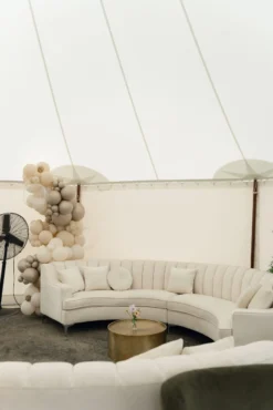Cream curved sectional with a gold coffee table under a white test
