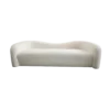 Modern beige shearling sofa with wave back. One piece cushion / seat. No visible legs.
