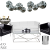 Black and white themed lounge area with leather furniture. White sofa with silver accents, two black boxy chairs. Silver and glass rectangle coffee table in front of the couch with a silver side table. Silver floor length champagne bucket behind a chair and disco balls hanging from the ceiling.