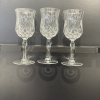 Crystal Lorren cut glass wine glasses held by the stem.