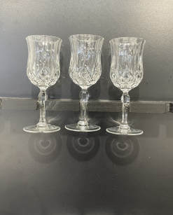 Crystal Lorren cut glass wine glasses held by the stem.