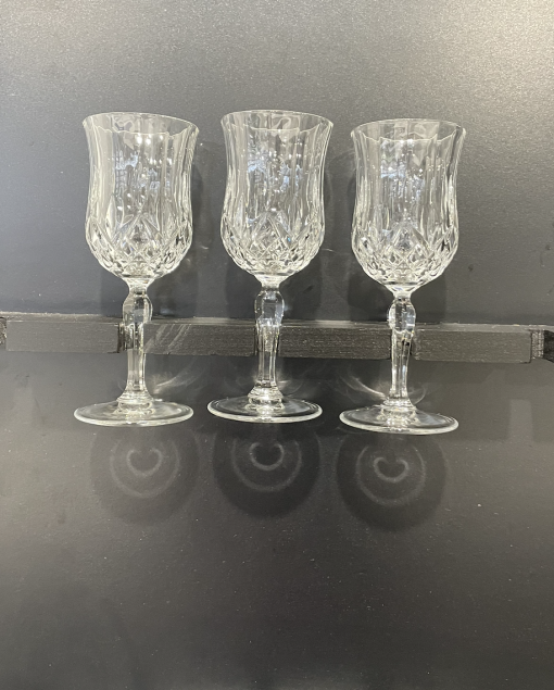 Crystal Lorren cut glass wine glasses held by the stem.