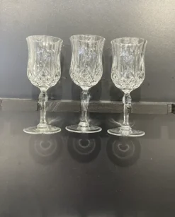 Crystal Lorren cut glass wine glasses held by the stem.